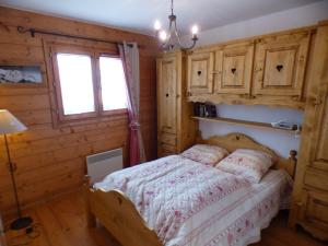 Un dormitorio con una cama con paredes de madera y una ventana en Appartement Villard-sur-Doron, 3 pièces, 7 personnes - FR-1-594-75, en Villard-sur-Doron