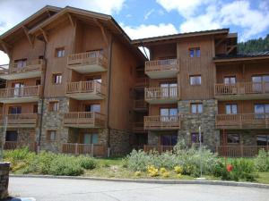 - un grand bâtiment avec des balcons sur le côté dans l'établissement Appartement Villard-sur-Doron, 3 pièces, 7 personnes - FR-1-594-75, à Villard-sur-Doron