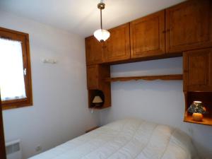 a bedroom with a bed and wooden cabinets at Appartement Les Saisies, 2 pièces, 5 personnes - FR-1-594-92 in Hauteluce