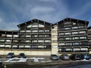 a large building with cars parked in a parking lot at Appartement Les Saisies, 2 pièces, 5 personnes - FR-1-594-92 in Hauteluce