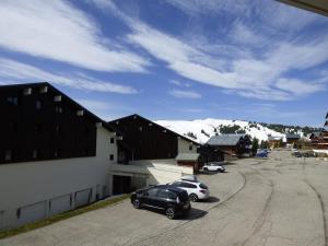 a black car and a white car parked in a parking lot at Appartement Les Saisies, 2 pièces, 5 personnes - FR-1-594-92 in Hauteluce