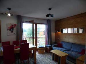 a living room with a blue couch and a table at Appartement Les Saisies, 3 pièces, 8 personnes - FR-1-594-71 in Hauteluce