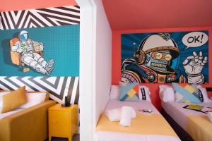 a room with two beds and a mural of a astronaut at Casual Pop Art Benidorm in Benidorm