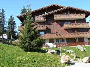 un grande edificio con un albero di fronte di Appartement Les Saisies, 2 pièces, 4 personnes - FR-1-594-168 a Hauteluce