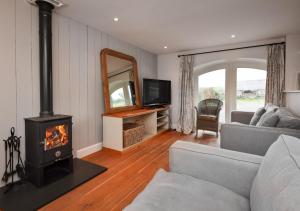 a living room with a couch and a fireplace at Geufron Barn in Aberdaron