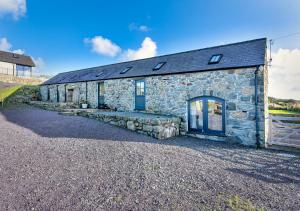 an old stone cottage with a blue door at Geufron Barn in Aberdaron