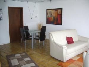 a living room with a white couch and a table at Ferienwohnung Erika in Grenzach-Wyhlen +6 photos
