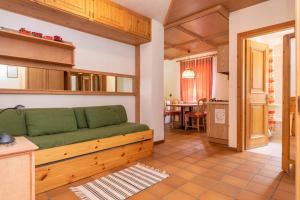 ein Wohnzimmer mit einem grünen Sofa und einem Tisch in der Unterkunft Ciasa Molino 306 in Falcade