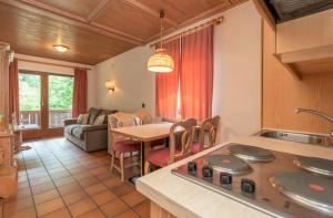 eine Küche und ein Wohnzimmer mit einem Tisch und einem Sofa in der Unterkunft Ciasa Molino 306 in Falcade