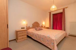 a bedroom with a bed and a dresser and a window at Ciasa Molino 306 in Falcade