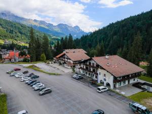 a parking lot with cars parked in front of a building at Ciasa Molino 306 in Falcade