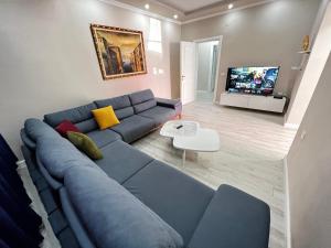 Golden Cherry في تيرانا: غرفة معيشة مع أريكة زرقاء وتلفزيون