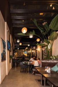 a dining room with people sitting at tables in a restaurant at The Compass Hotel in Amman