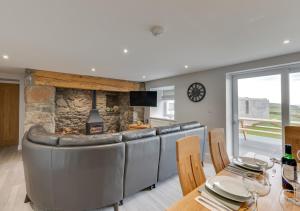 a living room with a couch and a stone fireplace at Ty Mawr in Aberdaron