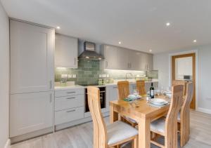 a kitchen with a wooden table with chairs and a dining room at Ty Mawr in Aberdaron