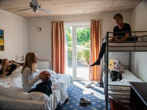 a group of people in a bedroom with bunk beds at Hotel Søgården Brørup in Brørup