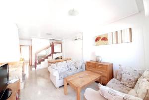ein Wohnzimmer mit einem Sofa und einem Tisch in der Unterkunft Amapolas by Villas&You in Orihuela