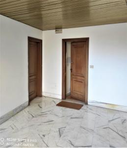 ein leeres Zimmer mit zwei Türen und Fliesenboden in der Unterkunft Dependace il David di Michelangelo in Florenz