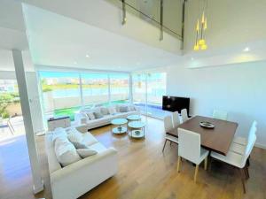 ein Wohnzimmer mit einem weißen Sofa und einem Tisch in der Unterkunft Villa Olivo Gran Alacant by Villas&You in Gran Alacant