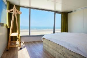 a bedroom with a bed and a view of the ocean at Slaapzand in Domburg