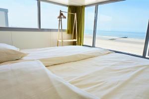 a bedroom with a bed with a view of the beach at Slaapzand in Domburg