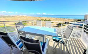 a table and chairs on a balcony with the ocean at Bahia Blanca Arenales del Sol by Villas&You in Arenales del Sol