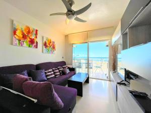 a living room with a couch and a flat screen tv at Bahia Blanca Arenales del Sol by Villas&You in Arenales del Sol