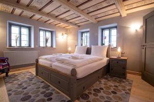 a bedroom with a large bed in a room with windows at außergewöhnliches, historisches, spätgotisches Wohnhaus von 1519, Gries 5 in Gera