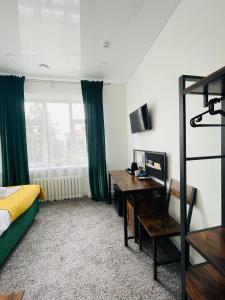 a bedroom with a bed and a desk and a window at Green apartments Easy Kaunas in Kaunas
