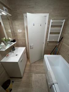 a bathroom with a white sink and a tub at Apartament de lux intr-o zona rezidentiala linistita in Iaşi