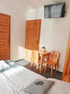 a bedroom with a bed and a table and chairs at Willa na górskim szlaku in Małe Ciche