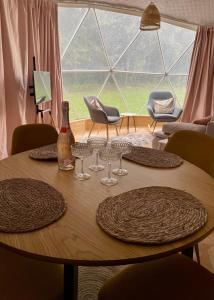 a wooden table with glasses and a bottle of wine at beGLAMP - Glamping nad Zalewem Próba in Brzeźnio