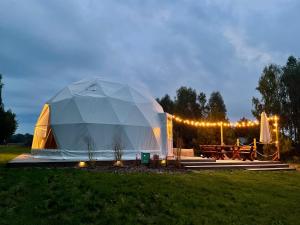 ein großes Zelt auf einem Feld mit einem Picknicktisch in der Unterkunft beGLAMP - Glamping nad Zalewem Próba in Brzeźnio