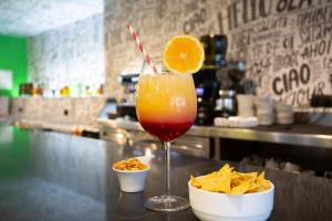a drink with an orange on a counter with chips at Casual Pop Art Benidorm in Benidorm