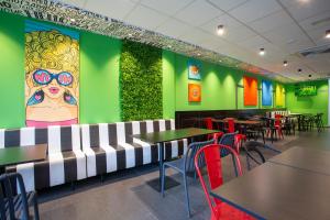 a restaurant with tables and chairs and a colorful wall at Casual Pop Art Benidorm in Benidorm