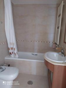 y baño con lavabo, bañera y aseo. en Precioso apartamento Campo Golf, en Huesca