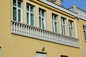a yellow building with a white balcony at Family Hotel Chiplakoff in Burgas