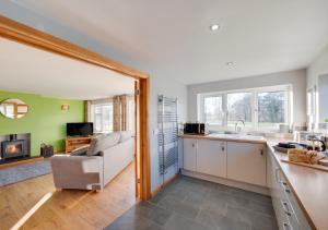 an open kitchen and living room with a couch at Drws Nesa in Tregaron