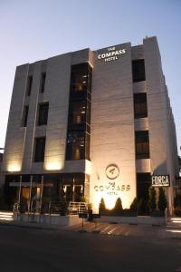 un edificio con un cartello sulla parte anteriore di The Compass Hotel ad Amman