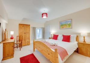 a bedroom with a large bed with red pillows at Pwllglas in Darowen