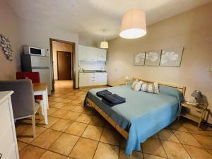 a bedroom with a blue bed and a kitchen at Borgo del Nibbio in Porto Levante