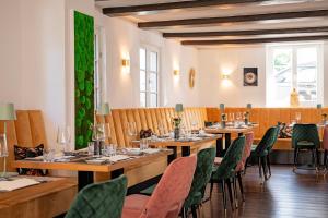 a restaurant with wooden tables and green chairs at Hotel Essgold in Ratingen