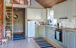 een keuken met witte kasten en een witte koelkast bij Lovely Home In Fossdal With Kitchen in Fossdal