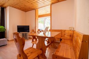 ein Esszimmer mit einem Holztisch und Stühlen in der Unterkunft Miraflor Carmen - Arosa Holiday in Arosa