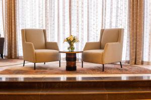 twee stoelen en een tafel met een vaas met bloemen bij InterContinental Lusaka, an IHG Hotel in Lusaka