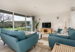 un soggiorno con 2 sedie blu e una TV di Ty Nant a Dinas