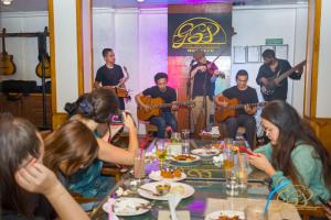 un grupo de personas sentadas alrededor de una mesa con instrumentos en Yalamul Garden, en Pātan