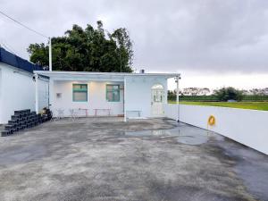 un edificio blanco con un patio enfrente en 宜蘭五結羅東 田中268, en Yilan City