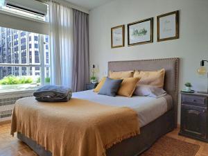 a bedroom with a bed with a large window at PORTEñO CENTRAL apart GALERIAS PACIFICO in Buenos Aires