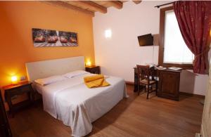 a bedroom with a bed and a desk and a window at Villa Maria Luigia in San Biagio di Callalta